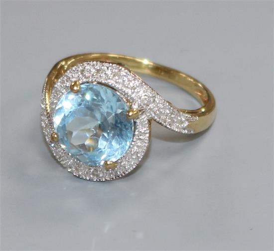 A modern 9ct gold, blue topaz and diamond set dress ring, size M.